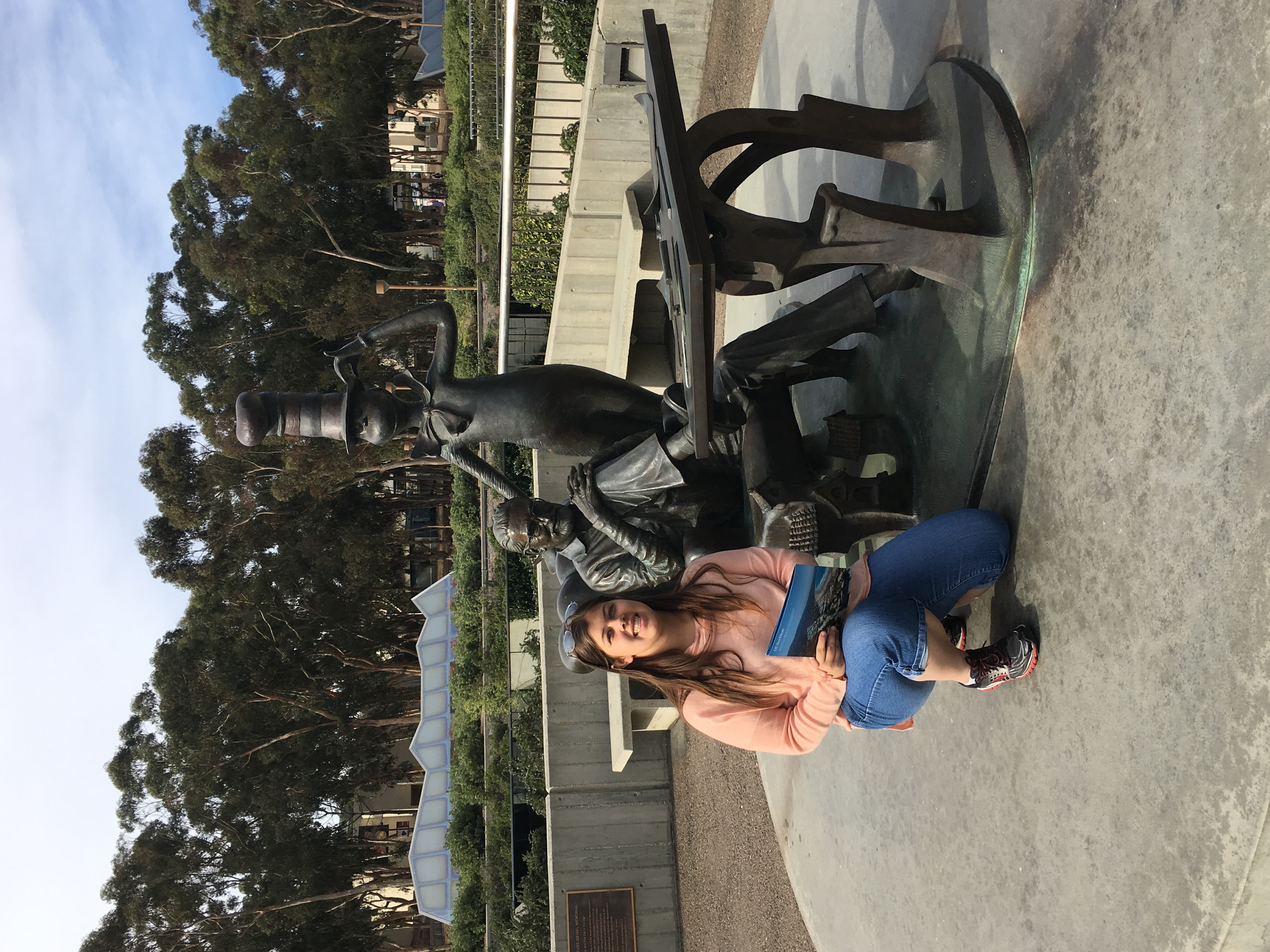 A photo of me kneeling next to the Dr. Seuss statue next to Geisel Library.